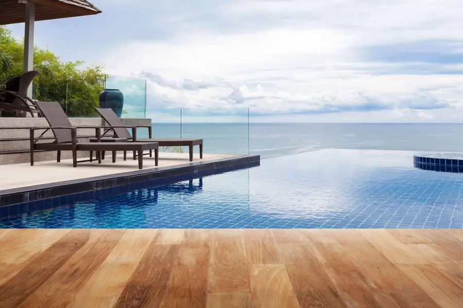 Backyard swimming pool enclosed by a frameless glass pool safety fence