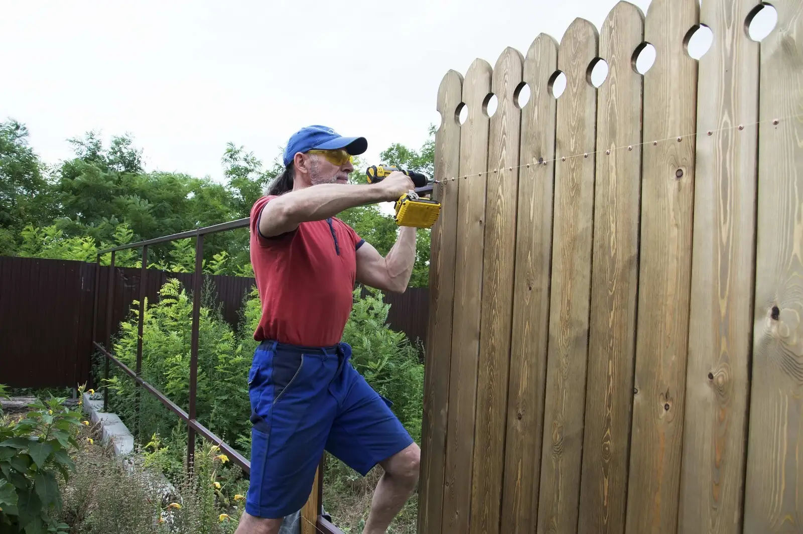 A pool fence gate latch being checked during winter maintenance