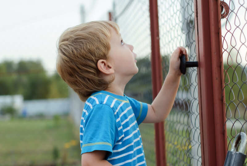 young child opening pool fence